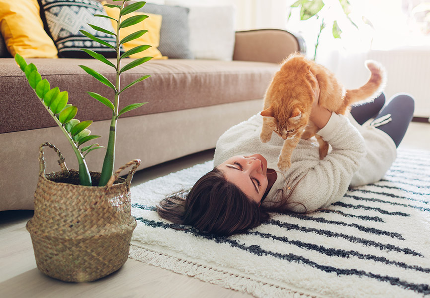 Girl cuddling cat on the floor
